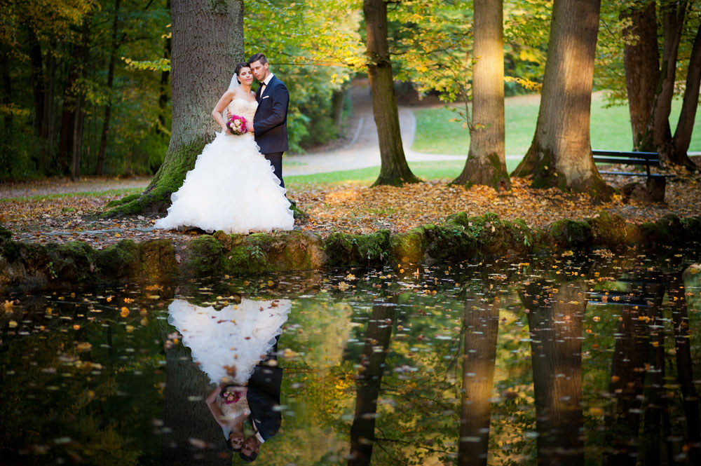 Ein professioneller Hochzeitsfotograf fotografiert ein glückliches Brautpaar im Sonnenuntergang.