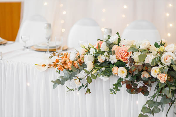 Stilvolle Hochzeitsdekoration mit weißen Rosen und goldenen Akzenten