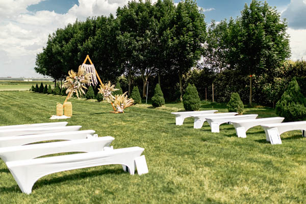 Romantische Hochzeitsdekoration mit Blumenschmuck und edlem Stoff für Trauung im Visioplex