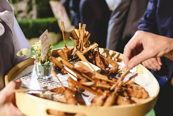 Serviceteam reicht stilvoll angerichtete Mini-Gerichte bei einem servierten Buffet.